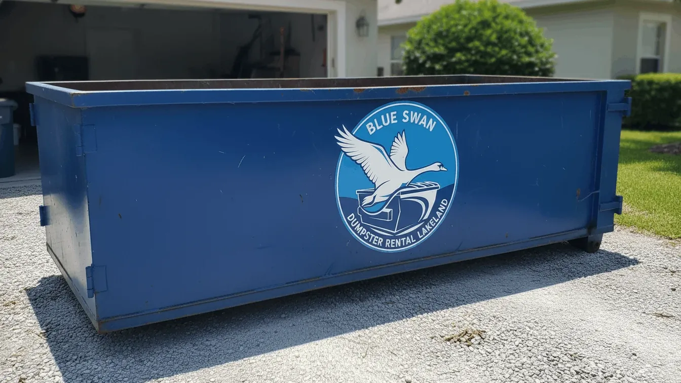 Junk removal in Lakeland: a 20 yard roll-off on plywood outside an open carport on the east side of the city, half loaded with a sagging couch, a dead chest freezer, shelving, bagged clothing and a rolled indoor-outdoor carpet off the slab. Junk removal in Lakeland: a 20 yard roll-off on plywood outside an open carport on the east side of the city, half loaded with a sagging couch, a dead chest freezer, shelving, bagged clothing and a rolled indoor-outdoor carpet off the slab.